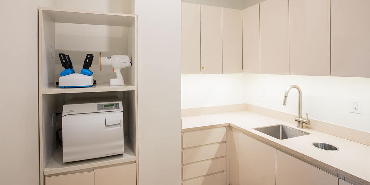 beige cabinets with sink and dental equipment