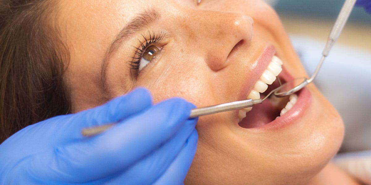 Closeup of person's mouth and dental instruments