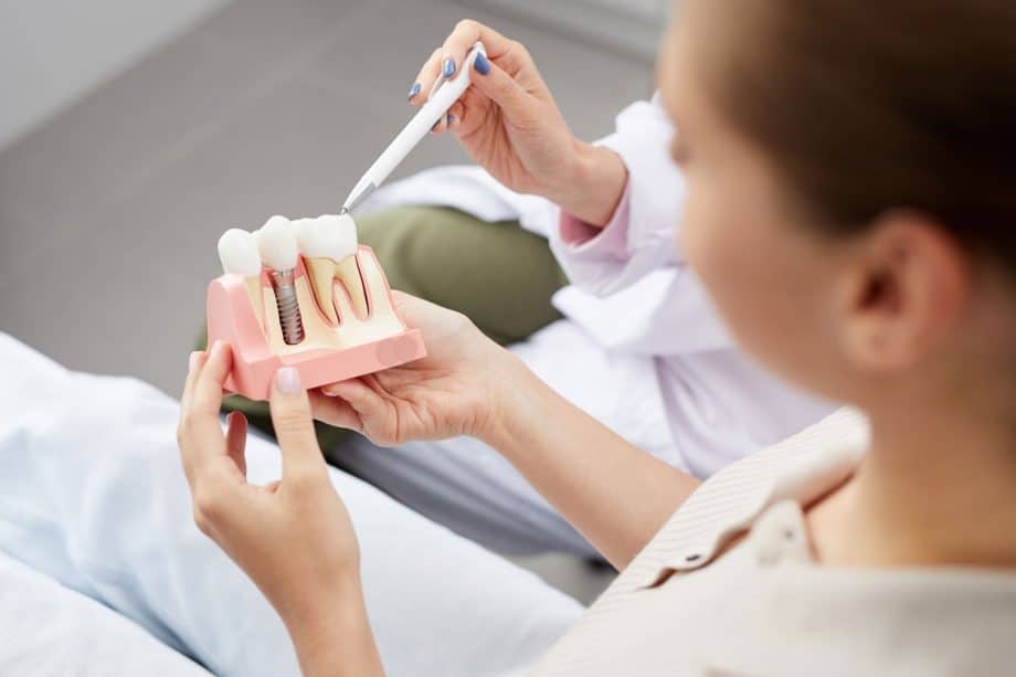 dental patient holding model of dental implants