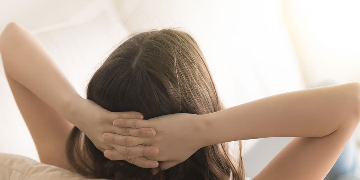 person relaxing with their hands behind their head