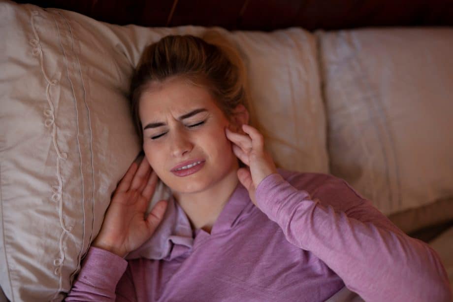girl pressing side of head where TMJ is located