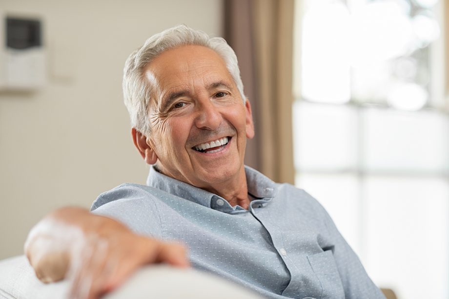 senior man on couch, smiling